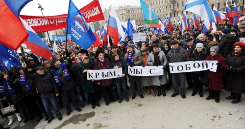 Nga tung chiến dịch tuyên truyền về Ukraine ảnh 1 Người dânở thành phốSt.Petersburg, Nga, biểu tình để bày tỏ sựủng hộ tộcngười Nga ở Crimea. Họ cầm những tấm biển ghi 'Chúng ta và Crimea là một'.Ảnh: AFP