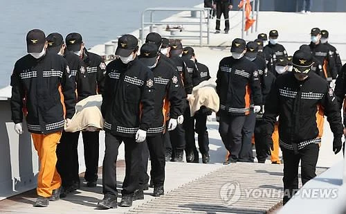 Cảnh sát đưa thi thể các nạn nhân vào bờ ngày 20-4. Ảnh: Yonhap
