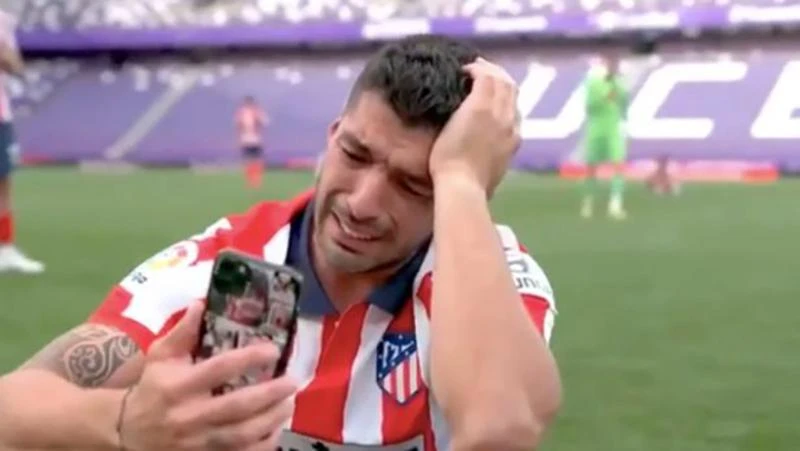 Suarez vừa nhìn điện thoại vừa khóc. ẢNH: GETTY Suarez vừa nhìn điện thoại vừa khóc. ẢNH: GETTY