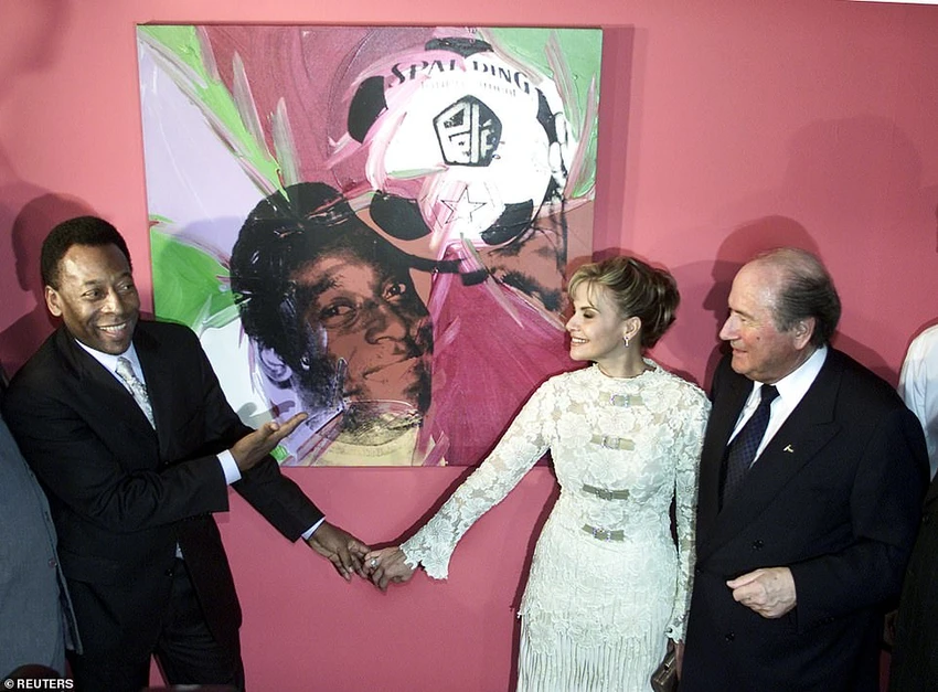 Pele với người vợ thứ hai Assiria Lemos Seixas và cựu chủ tịch FIFA Sepp Blatter bên cạnh bức chân dung của Andy Warhol. ẢNH: REUTERS Pele với người vợ thứ hai Assiria Lemos Seixas và cựu chủ tịch FIFA Sepp Blatter bên cạnh bức chân dung của Andy Warhol. ẢNH: REUTERS