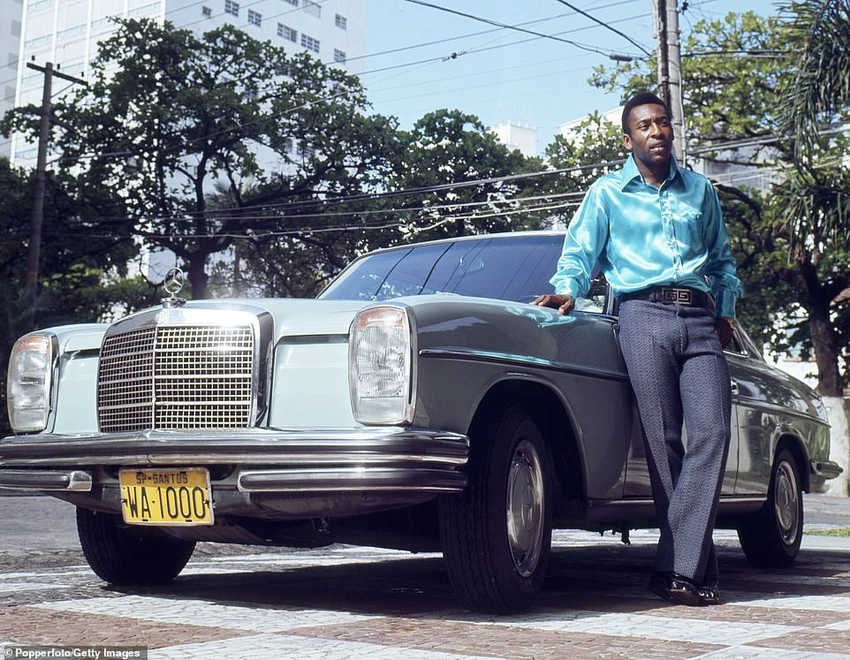 Mặc áo sơ mi lụa, quần tây sành điệu và đứng bên chiếc Mercedes-Benz bóng lộn, Pele khoe danh vọng và tài sản của mình vào năm 1966. ẢNH: GETTY Mặc áo sơ mi lụa, quần tây sành điệu và đứng bên chiếc Mercedes-Benz bóng lộn, Pele khoe danh vọng và tài sản của mình vào năm 1966. ẢNH: GETTY