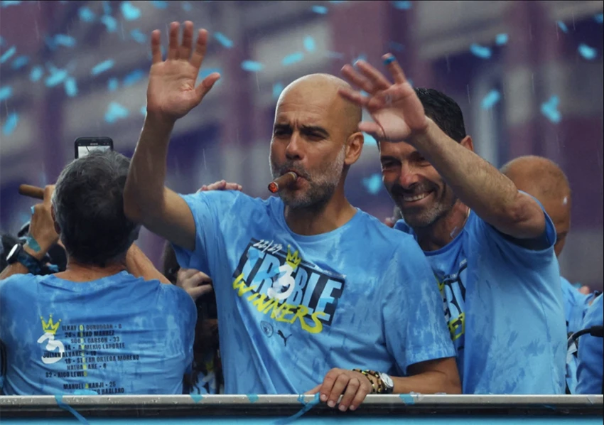 Pep Guardiola xuất hiện "cực ngầu" trong lễ diễu hành ăn mừng cú ăn ba lịch sử của Man City. ẢNH: AFP, REUTERS Pep Guardiola xuất hiện "cực ngầu" trong lễ diễu hành ăn mừng cú ăn ba lịch sử của Man City. ẢNH: AFP, REUTERS