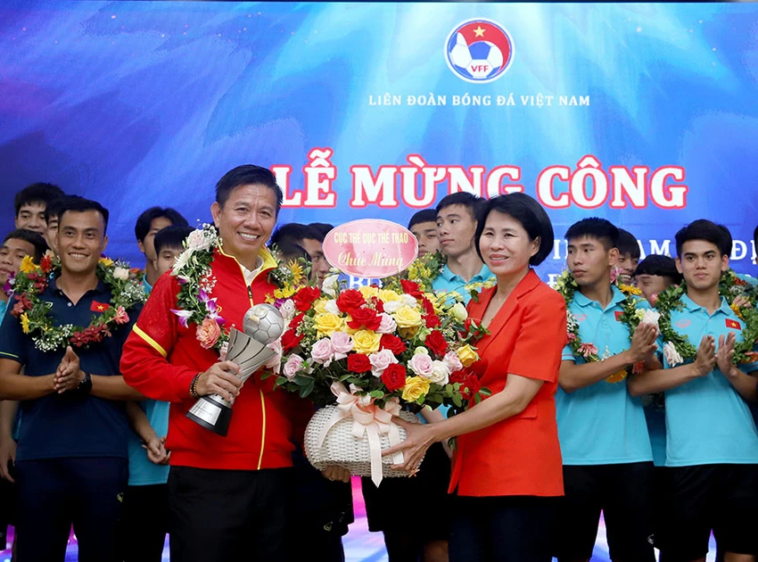 Phó Cục trưởng Cục TDTT Lê Thị Hoàng Yến tặng hoa chúc mừng HLV Hoàng Anh Tuấn và đội U-23 Việt Nam. ẢNH: VFF