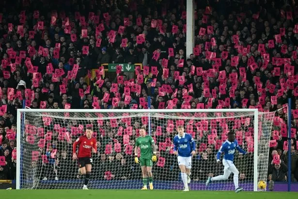 Fan Everton giơ những tấm bảng màu hồng phản đối Premier League trừ CLB của họ 10 điểm. ẢNH: GETTY
