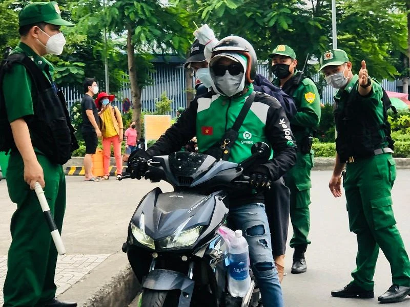 Lực lượng Thanh niên xung phong nhắc nhở xe công nghệ bát nháo bắt khách tại cửa ngõ vào sân bay. Ảnh: PHONG ĐIỀN