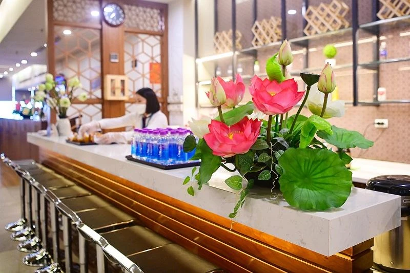 Hành khách được tiếp đón với quầy thủ tục trang trí hoa sen. Ảnh: VNA Hành khách được tiếp đón với quầy thủ tục trang trí hoa sen. Ảnh: VNA