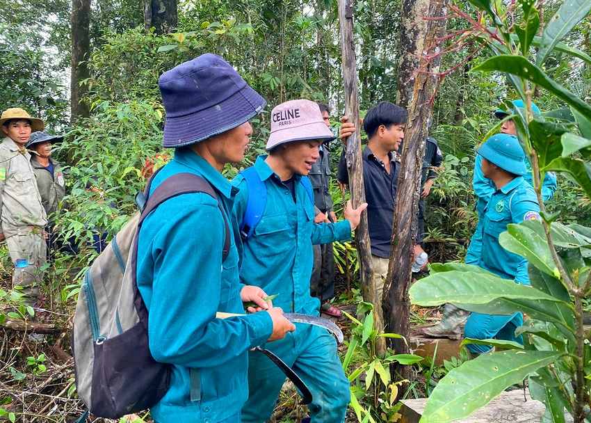 Lực lượng chức năng và người dân tìm thấy bà Y Nhựa sau ba ngày đi lạc trong rừng. Ảnh: CA.