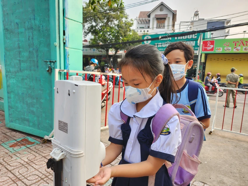 Học sinh Trường Tiểu học Lê Văn Thọ, quận Gò Vấp đeo khẩu trang, rửa tay trước khi vào trường. Ảnh: NGUYỄN QUYÊN