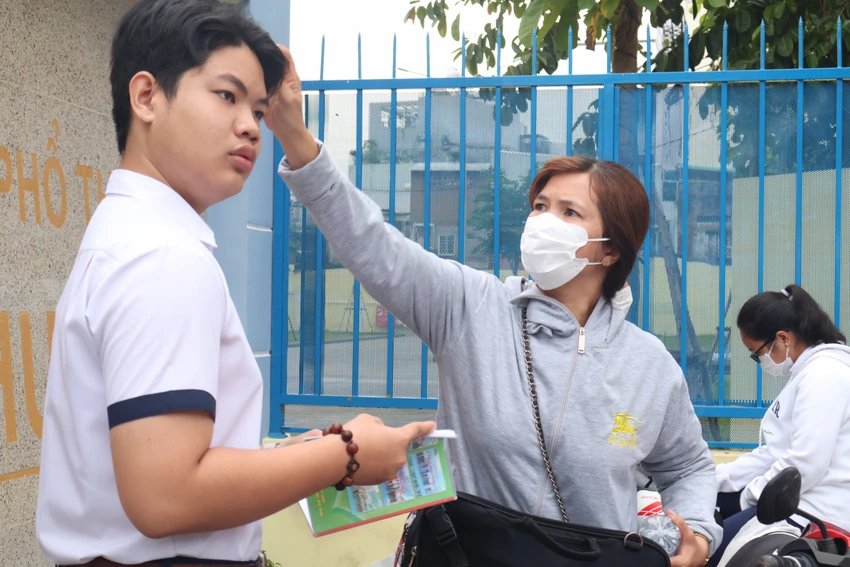 Vuốt lại mái tóc, chúc con thi thật tốt. Ảnh: TRẦN MINH Vuốt lại mái tóc, chúc con thi thật tốt. Ảnh: TRẦN MINH