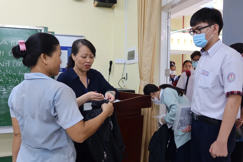 Thí sinh dự thi được hướng dẫn khu vực để đồ. Ảnh: TRẦN MINH Thí sinh dự thi được hướng dẫn khu vực để đồ. Ảnh: TRẦN MINH