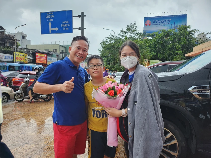 Ông bố tặng hoa cho con gái sau khi hoàn thành kỳ thi tại điểm thi Trường THPT Nguyễn Thượng Hiền, quận Tân Bình. Ảnh: NGUYỄN QUYÊN