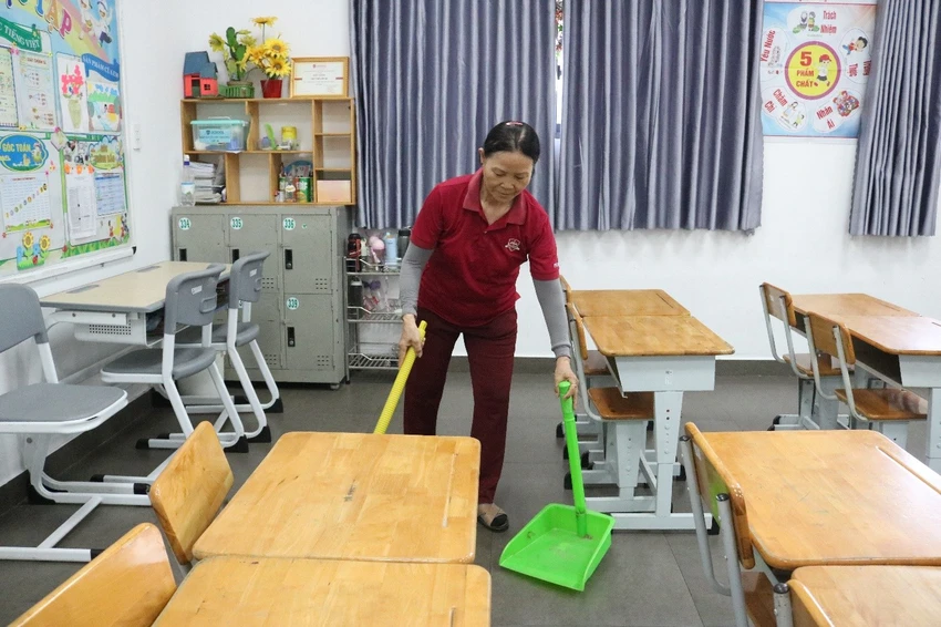 Cô Nguyễn Thị Lực – Nhân viên tạp vụ đang lau dọn lớp học trước khi học sinh đến trường.jpg