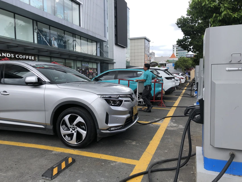 Các tài xế đang sạc xe điện tại một trạm sạc ở phường Tân Sơn Nhất. Ảnh: THY NHUNG tram-sac.JPG