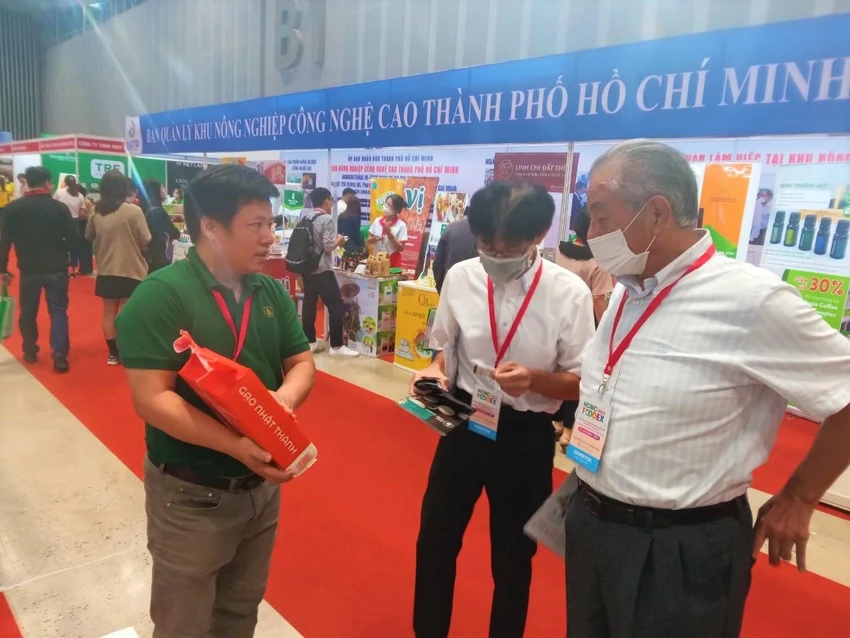 Khách tham quan quan tâm tìm hiểu sản phẩm gạo của doanh nghiệp
