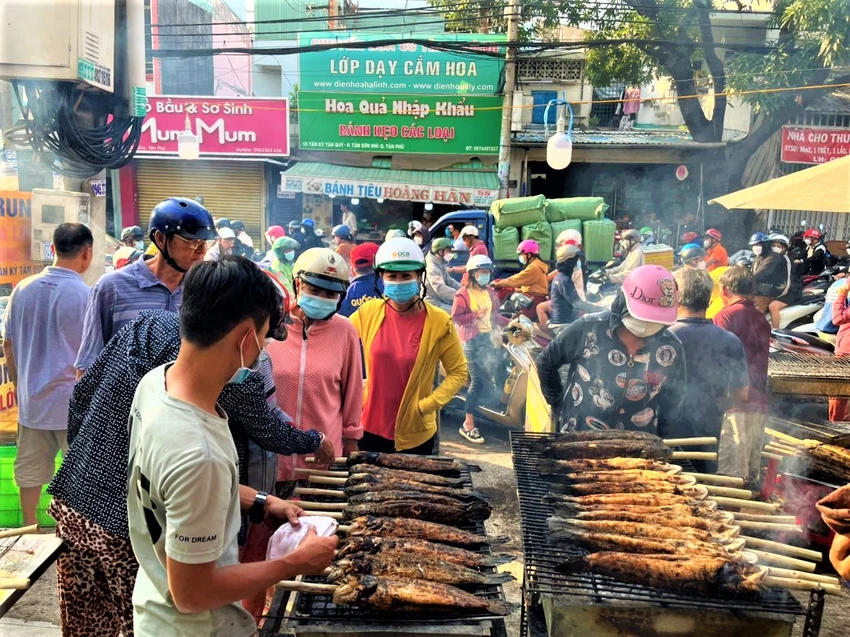 Người dân chọn mua những con cá lớn, nhỏ đang được nướng. Người dân chọn mua những con cá lớn, nhỏ đang được nướng.