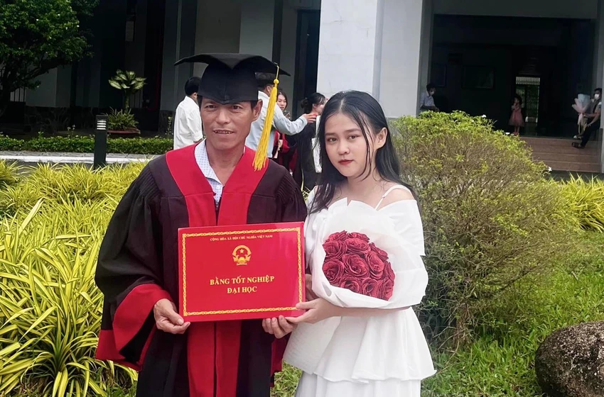 Khoảnh khắc con gái khoác bộ lễ phục cử nhân cho người cha mặc khiến nhiều người xúc động. Ảnh: NVCC