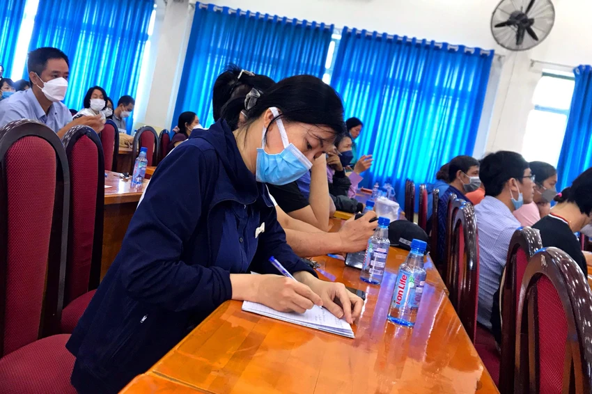 Chị ĐTV cẩn thận ghi chép thông tin cho con tại buổi tư vấn tuyển sinh. Ảnh: TÚ NGÂN. Chị ĐTV cẩn thận ghi chép thông tin cho con tại buổi tư vấn tuyển sinh. Ảnh: TÚ NGÂN.