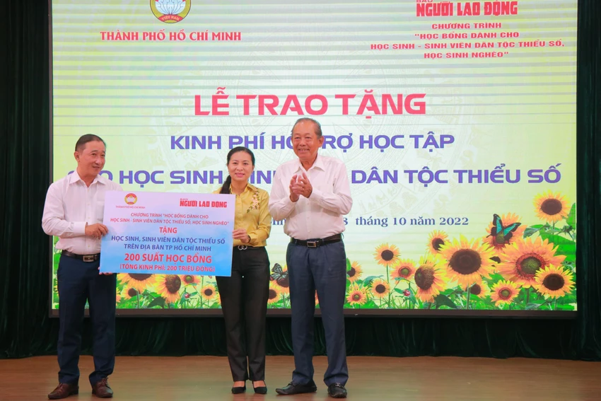 Ông Bùi Thanh Liêm, Phó Tổng Biên tập Báo Người Lao Động và ông Ông Trương Hòa Bình, Nguyên Ủy viên Bộ Chính trị - Nguyên Phó Thủ tướng Thường trực Chính phủ trao bảng tượng trưng 200 suất kinh phí hỗ trợ học tập học sinh, sinh viên dân tộc thiểu số. Ảnh: VÕ THƠ