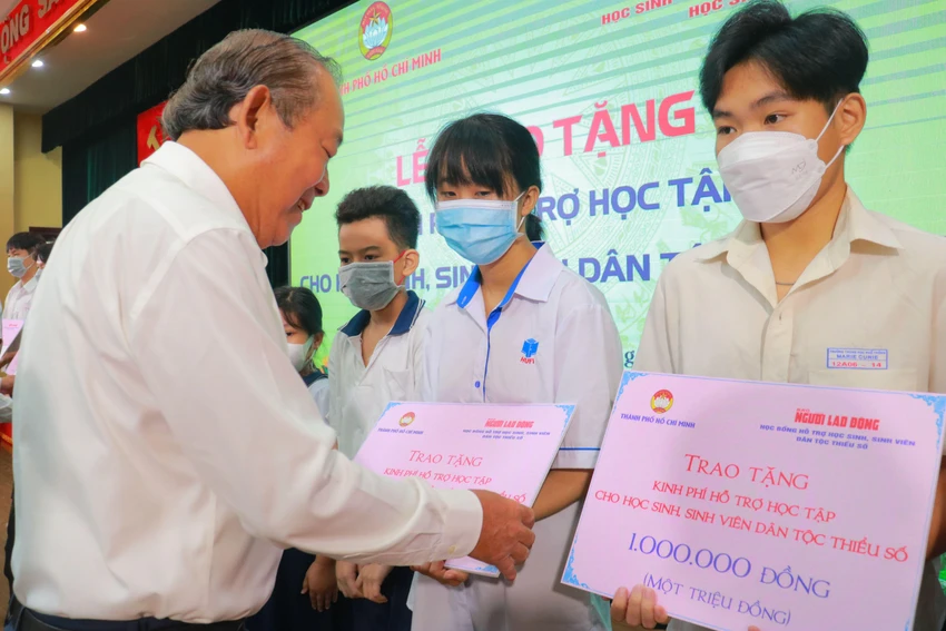 Ông Trương Hòa Bình, Nguyên Ủy viên Bộ Chính trị, nguyên Phó Thủ tướng Thường trực Chính phủ trao học bổng cho các em. Ảnh VÕ THƠ