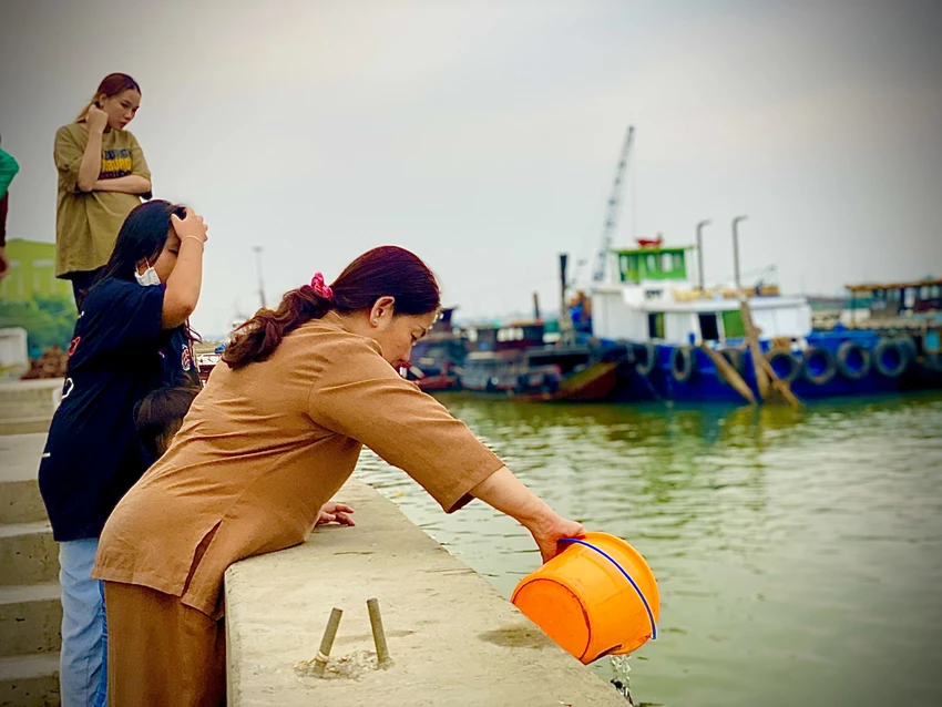 Tại khu vực thả cá phóng sinh nhiều người đến mua cá, khấn vái và thả cá xuống sông. Ảnh: T.N Tại khu vực thả cá phóng sinh nhiều người đến mua cá, khấn vái và thả cá xuống sông. Ảnh: T.N