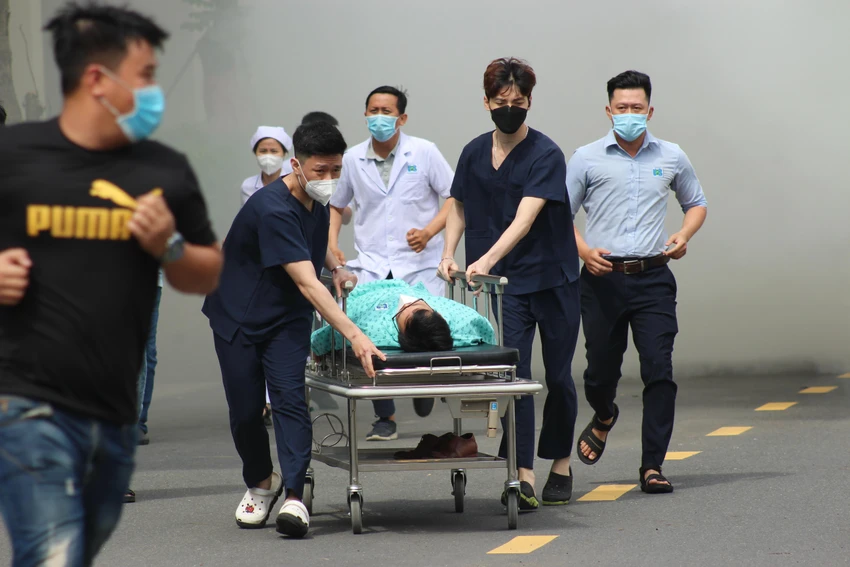 Bệnh nhân và người trong bệnh viện được hỗ trợ thoát khỏi đám cháy. Ảnhr: TS Bệnh nhân và người trong bệnh viện được hỗ trợ thoát khỏi đám cháy. Ảnhr: TS