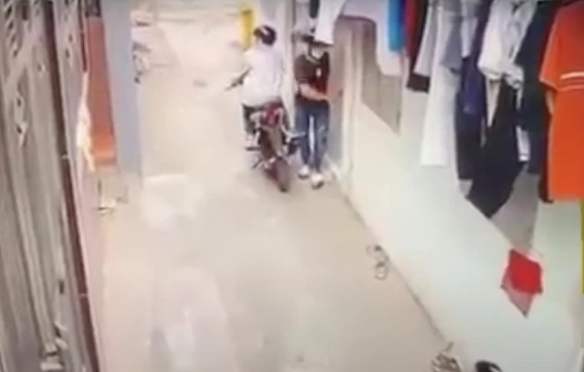 An ngồi trên xe máy, Hiền đang phá khoá phòng trọ để trộm cắp được camera ghi lại. Ảnh: Cắt từ clip An ngồi trên xe máy, Hiền đang phá khoá phòng trọ để trộm cắp được camera ghi lại. Ảnh: Cắt từ clip