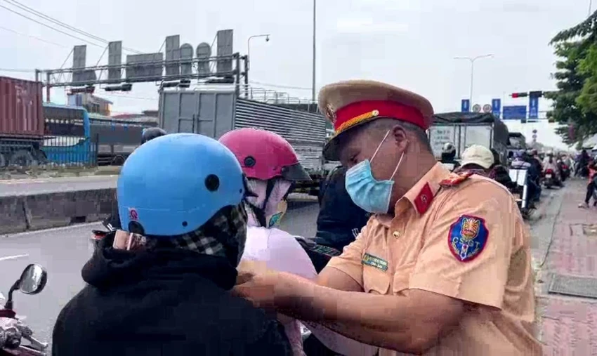 Lực lượng CSGT đội BÌnh Triệu tặng nón bảo hiểm cho người dân về quê đón lễ. Ảnh: TS Lực lượng CSGT đội BÌnh Triệu tặng nón bảo hiểm cho người dân về quê đón lễ