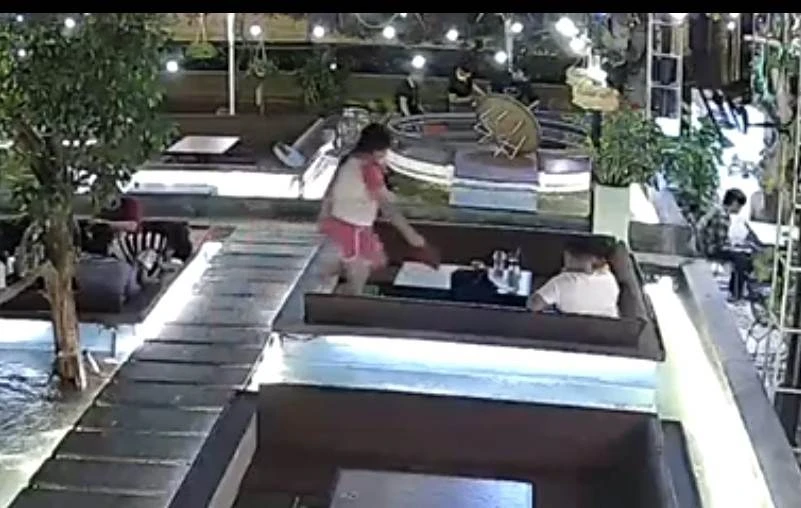 Bé gái nhặt ví chị Nhung để quên mang về bàn người đàn ông. Ảnh: Cắt từ clip Bé gái nhặt ví chị Nhung để quên mang về bàn người đàn ông. Ảnh: Cắt từ clip