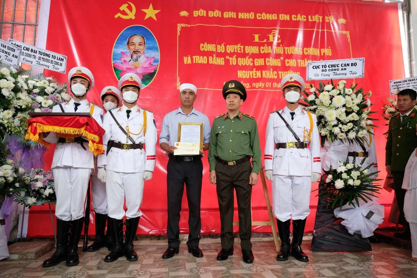 Thiếu tướng Lê Văn Tuyến - Thứ trưởng Bộ Công an, trao quyết định cho thân nhân liệt sỹ Thường. Ảnh: VT