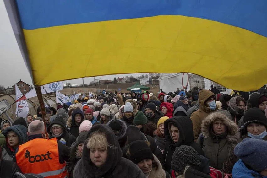 Một tình nguyện viên người Ukraine cầm cờ và hướng dẫn hàng trăm người tị nạn đến cửa khẩu biên giới ở Medyka, Ba Lan vào tháng 3-2022. Ảnh: AP Một tình nguyện viên người Ukraine cầm cờ và hướng dẫn hàng trăm người tị nạn đến cửa khẩu biên giới ở Medyka, Ba Lan vào tháng 3-2022. Ảnh: AP