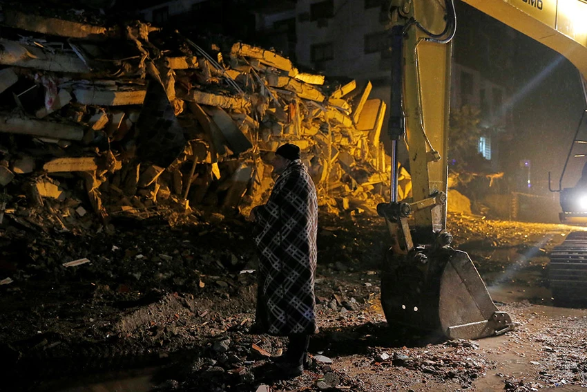Một người đàn ông đứng trước tòa nhà bị sập ở Osmaniye, Thổ Nhĩ Kỳ. Ảnh: REUTERS