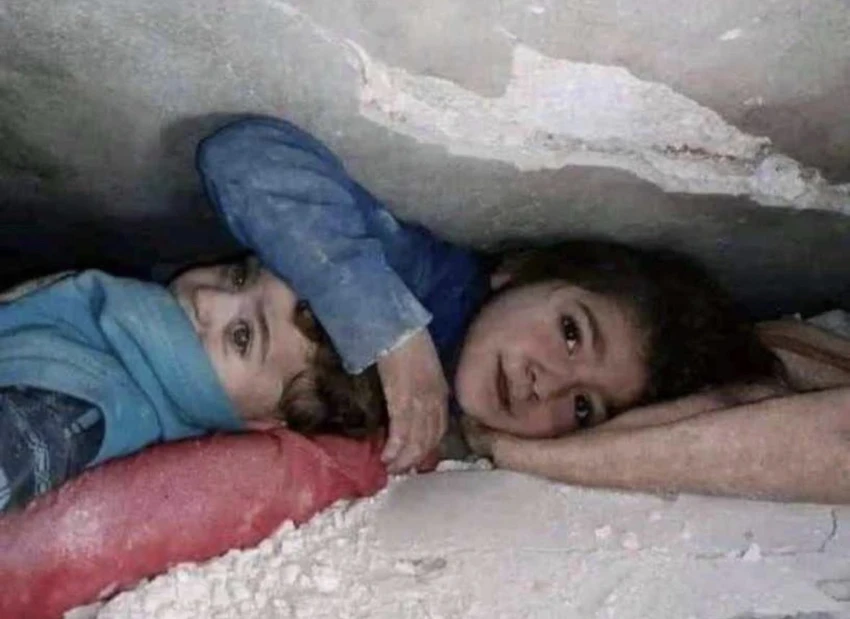 Bé gái 7 tuổi ở Syria che chắn cho em trai giữa đống đổ nát suốt nhiều giờ liền. Ảnh: TWITTER Bé gái 7 tuổi ở Syria che chắn cho em trai giữa đống đổ nát suốt nhiều giờ liền. Ảnh: TWITTER