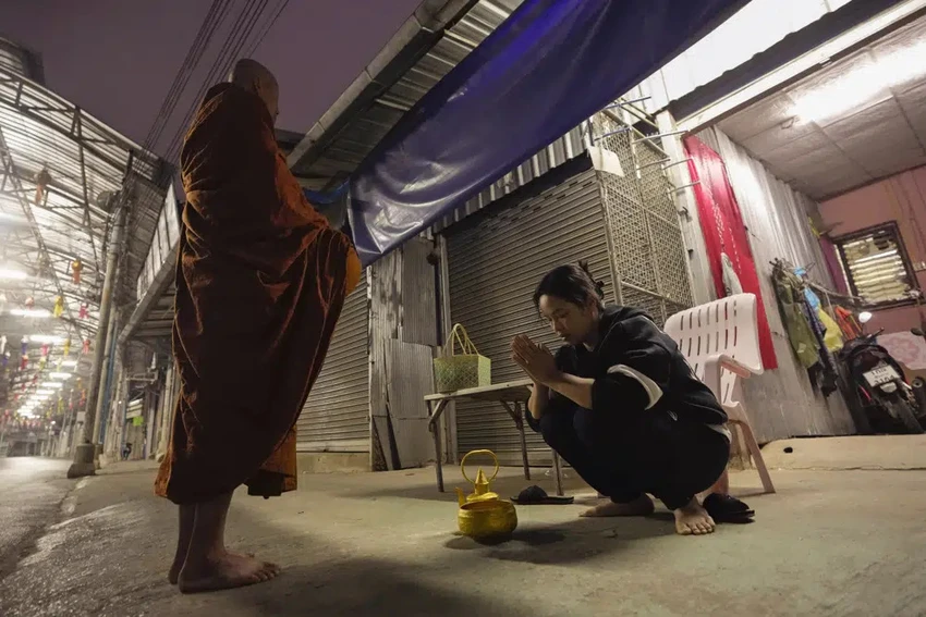 Mẹ của Duangphet Phromthep cầu nguyện sau khi cúng dường cho một nhà sư hôm 5-3. Ảnh: AP