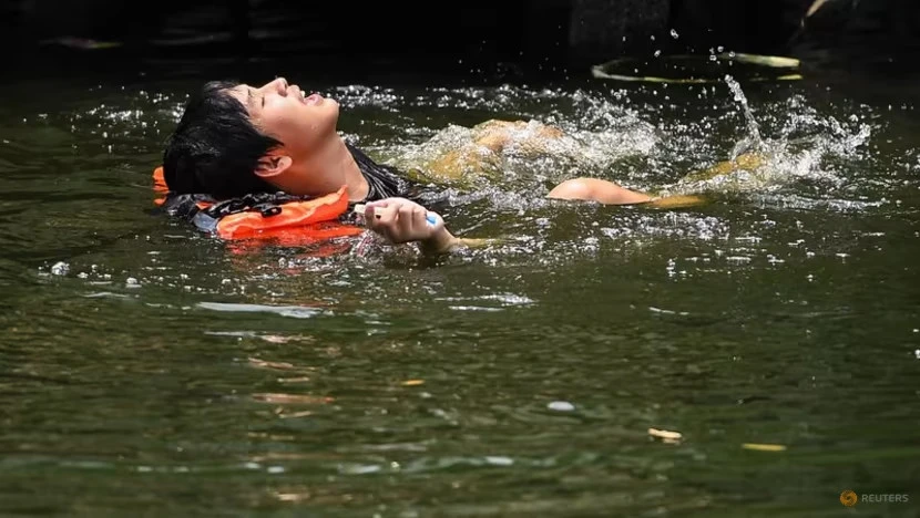 Một người đàn ông bơi trong một con kênh ở Bangkok (Thái Lan) ngày 22-4 khi nhiệt độ lên mức kỷ lục 45,4°C. Ảnh: REUTERS
