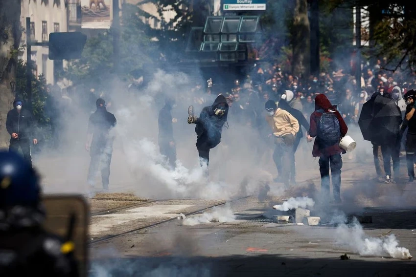 Người biểu tình ném hơi cay vào cảnh sát tại TP Nantes (Pháp) ngày 1-5. Ảnh: REUTERS