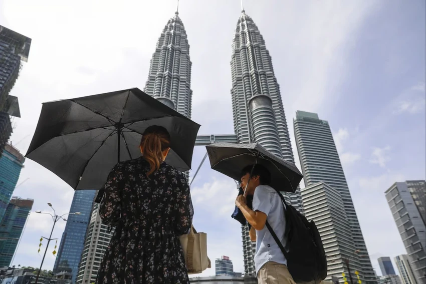 Người dân dùng ô để che nắng trong một ngày nắng nóng ở Kuala Lumpur (Malaysia) vào tháng 4. Ảnh: EPA