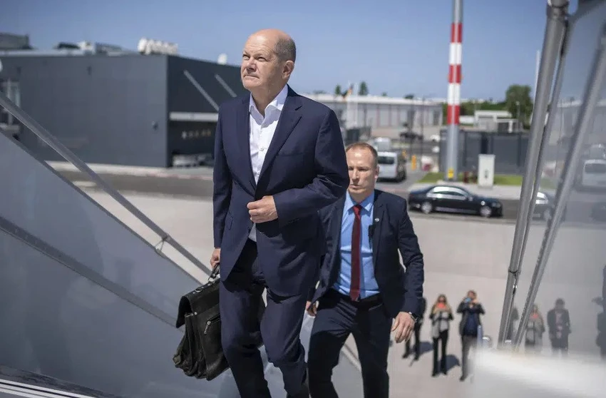 Thủ tướng Đức Olaf Scholz lên máy bay cùng với nhân viên cảnh vệ hôm 26-5. Ảnh: AP