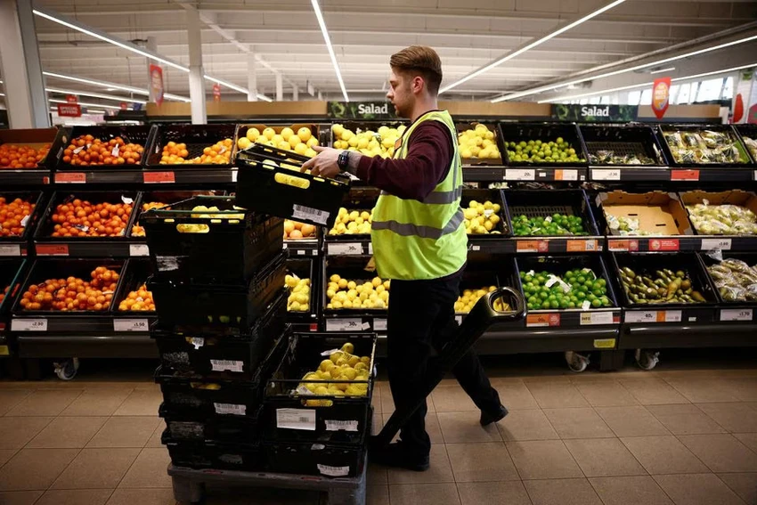 Nhân viên xếp hàng hóa tại một siêu thị ở London (Anh). Ảnh: REUTERS Nhân viên xếp hàng hóa tại một siêu thị ở London (Anh). Ảnh: REUTERS