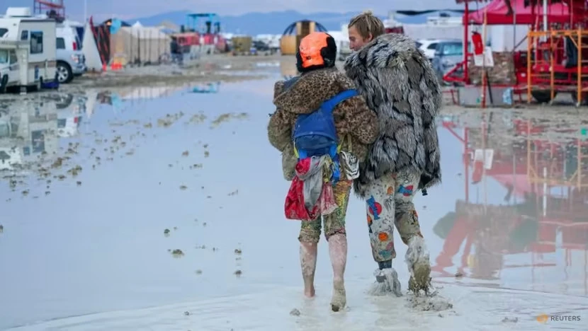 Những người tham dự lễ hội Burning Man ở bang Nevada (Mỹ) bị kẹt lại do mưa lớn ngày 2-9. Ảnh: USA TODAY