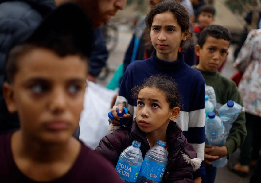 Trẻ em Palestine xếp hàng lấy nước tại TP Rafah (phía nam Gaza) ngày 5-12. Ảnh: REUTERS