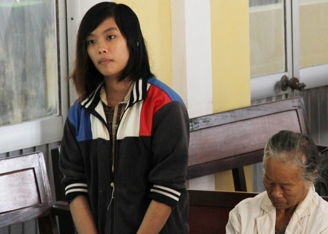 "Làm ở quán rất ít tiền. Do hết tiền nên 2 ngày trước đó Duyên rủ bị cáo đi cướp, lấy tiền xài. Hai đứa không có bàn bạc gì, chủ yếu gặp ai cướp đó", Xuyến khai. Theo bị cáo, do đi làm về vào đêm khuya nên lúc nào cũng mang dao theo bên người. Trước khi đón xe do ông Lý Văn Dũng chở đi, khoảng 19h, hai người vào tiệm Internet chơi đến gần 20h thì nghỉ. Trong ảnh: Duyên đứng nép mình ở một góc tòa. Bà nội khóc ngất khi thiếu nữ đồng tính lĩnh 12 năm tù