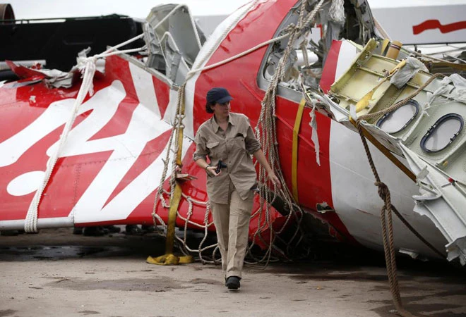 Một nhà điều tra của hãng Airbus đi gần phần đuôi của chiếc AirAsia QZ8501 trục vớt được, đưa về cảng Kumai, gần Pangkalan Bun, trung Kalimantan, Indonesia.