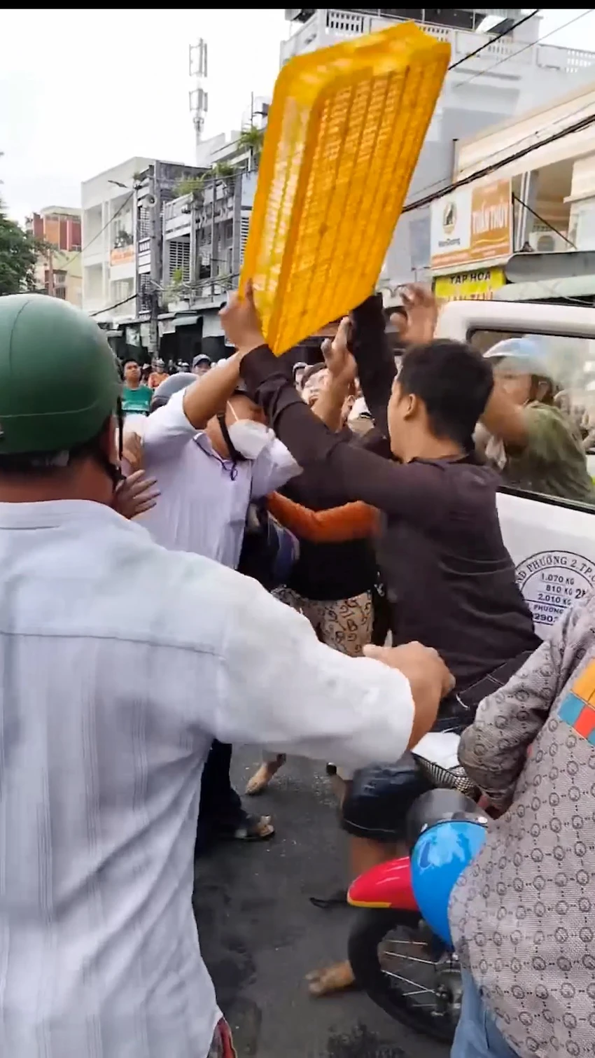 Tiểu thương chống lại lực lượng chức năng vì muốn giành lại khay hột vịt bị thu gom do bày bán dưới lòng đường. Ảnh cắt từ clip người dân cung cấp. Tiểu thương chống lại lực lượng chức năng vì muốn giành lại khay hột vịt bị thu gom do bày bán dưới lòng đường. Ảnh cắt từ clip người dân cung cấp.
